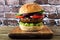 Portobello mushroom vegetarian burger on a wood serving board against a dark brick background