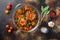 Portobello mushrooms,baked with cheddar cheese, cherry tomatoes and sage  in glass pot on old rustic metall dark background top