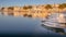 Portocolom town houses, harbour, port, golden light, sunrise, calm blue mediterranean sea, fishing boats, sandy beach, reflection