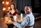 Portraif Of Happy Interracial Couple Sitting At Table In Restaurant, Drinking Wine