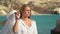 Portrain of young beautiful blond woman at stunning sea view holding mans white shirt in hands. Slow motion.