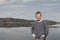 Portrait of 10 years caucasian boy with blonde hair standing in front of the lake in sunny day. Holiday domestic tourism