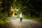 Portrait of 2 years old baby girl in forest walking by herself. Not wanting to follow parents