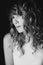 Portrait of a 36 year old woman with curly hair and brown slanting eyes. Soft selective focus. Black and white art photo