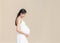 Portrait of 9 month pregnant young asian woman in white dress