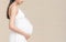 Portrait of 9 month pregnant young asian woman in white dress