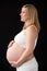 Portrait Of 9 months Pregnant Woman Wearing White On Black Background