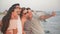 Portrait of Active Four People Taking Selfie Using Smartphone on the Beach at Summer Vacation Spending Time Together