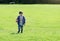 Portrait active little boy playing with toy airplane against green nature background, Child throwing foam airplane in green field