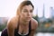 Portrait of active millenial woman jogging at dusk with an urban cityscape and sunset in the background