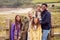 Portrait Of Active Multi-Cultural Family Standing By Gate On Winter Beach Vacation