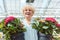 Portrait of an active senior woman holding two potted ornamental