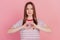 Portrait of adorable affectionate lady fingers show love gesture heart symbol on pink background