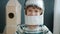 Portrait of adorable blond kid wearing astronaut helmet smiling against spaceship background