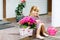 Portrait of adorable, charming toddler watering flowers with water can. Smiling happy child on summer day with colorful