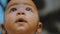 Portrait of adorable curious multiracial dark skin baby looking up.