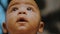 Portrait of adorable curious multiracial dark skin baby looking up. Slow motion