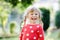 Portrait of adorable cute toddler girl of three years. Beautiful baby with blond hairs looking and smiling at the camera