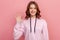 Portrait of adorable friendly teen with brown hair in hoodie standing waving hand, looking at camera