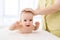 Portrait of adorable infant baby boy lying on stomach tummy, smiling looking at camera. Closeup of toddler training to