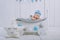 portrait of adorable infant baby in hat sleeping in wooden baby cot decorated