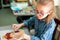 Portrait of adorable little girl smiling happily while enjoying art and craft lesson in art school working together with other