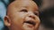 Portrait of adorable multiracial dark skin baby smiling. Slow motion