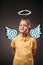 portrait of adorable preteen boy with drawn wings and nimbus as angel