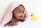 Portrait of adorable six month crawling African American baby covered in towel after bath time, happy smiling sweet little girl