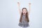 Portrait of adorable smiling little girl isolated on a white. Toddler with her hands up. Happy child. Cheerful and positive emotio