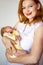 Portrait adorable smiling redhead mother posing with newborn baby feeling love enjoying motherhood