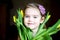 Portrait of adorable sunny child girl with tulips