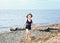 Portrait of adorable white Caucasian one toddler little girl with hat on her head going on lake sea gravel beach