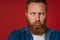 Portrait of adult bearded tattooed handsome frowning redhead man