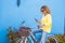 Portrait of adult beautiful young woman use phone and internet connection in outdoor leisure activity with the bike - blue and