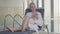 Portrait of adult Caucasian blond woman using phone and smiling. Charming young lady resting on sunbed in spa hotel on