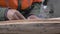 Portrait of an adult Caucasian male in work clothes diligently processing a log with a hand tool. Australian Aboriginal