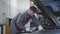 Portrait of adult Caucasian man in workwear examining open car hood manually and showing thumb up. Professional