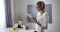 Portrait of adult Caucasian woman standing with tablet as little pretty schoolgirl writing in exercise book. Child