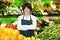 Portrait of adult female selling fruits and vegetables