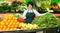 Portrait of adult female selling fruits and vegetables