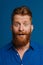 Portrait of adult handsome stylish redhead bearded surprised man