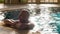 Portrait adult man relaxing in swimming pool near edge in luxury hotel