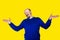 Portrait of adult man saying oops isolated on yellow background.