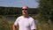 Portrait adult man in sunglasses on background green forest and lake water