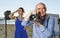 Portrait of adult photographer with his camera during photo shooting on sea coast