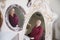 Portrait of an adult woman in a furniture store choosing herself a mirror. Several reflections in the mirrors