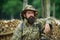 Portrait of adventure serious man extreme explorer. Man hunter in camouflage outdoor. Brutal hunter, bearded man in the