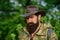 Portrait of adventure serious man extreme explorer. Man hunter in camouflage outdoor. Brutal hunter, bearded man in the