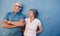 Portrait of affectionate mature couple against a blue wall